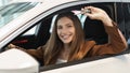 Happy young woman showing car key from auto window, purchasing new vehicle at showroom store, banner design Royalty Free Stock Photo