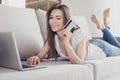 Happy young woman showing credit card and doing internet online Royalty Free Stock Photo