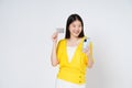 Happy young woman showing credit card while holding mobile phone isolated white background Royalty Free Stock Photo