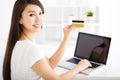 Happy young woman showing credit card and laptop Royalty Free Stock Photo