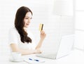 Happy young woman showing credit card and laptop Royalty Free Stock Photo