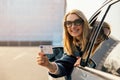 young woman showing her new driver license out of car window after successful test at driving school. copy space Royalty Free Stock Photo