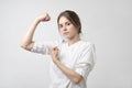 Happy young woman showing her strong hand.