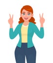 Happy young woman showing victory or V sign. Trendy smiling girl making peace or two gesture with hand fingers. Female character. Royalty Free Stock Photo