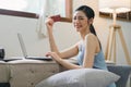 A happy young woman is shown shopping online using her laptop and credit card at home. Royalty Free Stock Photo