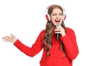 Happy young woman singing into microphone Royalty Free Stock Photo