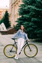 Happy young woman sitting on bicycle by city road Royalty Free Stock Photo