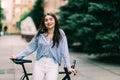 Happy young woman sitting on bicycle by city road Royalty Free Stock Photo
