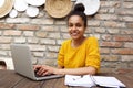 Happy young woman sitting at cafe with laptop Royalty Free Stock Photo