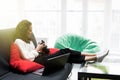 Happy young woman sitting on couch and using modern dslr photo camera Royalty Free Stock Photo