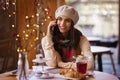 Happy young woman sitting at desk in the cafe and talking on her mobile phone Royalty Free Stock Photo