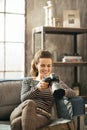 Happy young woman sitting on divan and using dslr Royalty Free Stock Photo