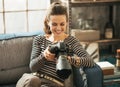 Happy young woman sitting on divan and using dslr Royalty Free Stock Photo