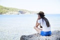 Happy young woman sitting, enjoy life on the beach at Sea. Royalty Free Stock Photo