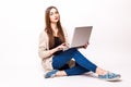 Happy young woman sitting on the floor with crossed legs and using laptop Royalty Free Stock Photo