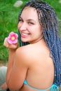 Happy young woman sitting on the green grass with a flower Royalty Free Stock Photo