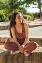 Happy young woman sitting with her legs crossed. Royalty Free Stock Photo