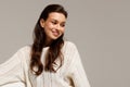 Happy young woman sitting on sofa at home and looking at camera. Portrait of comfortable woman in winter clothes relaxing on Royalty Free Stock Photo