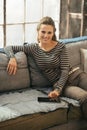 Happy young woman sitting on sofa and using tablet Royalty Free Stock Photo