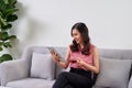 Happy young woman sitting on sofa and using tablet pc in office Royalty Free Stock Photo