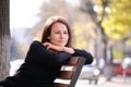 Happy young woman sitting on street bench enjoying free time during work break on warm autumn day. Wellness and resting Royalty Free Stock Photo