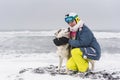 Happy young woman with sled dog on the beach Royalty Free Stock Photo