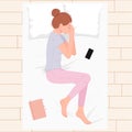 Happy young woman sleeping on pillows at night in pink pajamas top view. Young woman sleeping in bed with phone and book on Royalty Free Stock Photo