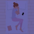 Happy young woman sleeping on pillows at night in pink pajamas top view. Young woman sleeping in bed with phone and book on Royalty Free Stock Photo