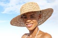 Happy young woman smiling at the beach side, wearing sun hat and bikini, portrait of African latin American woman in sunny summer Royalty Free Stock Photo