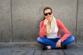 Happy young woman is smiling with a blank wall outside with sung