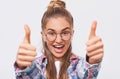 Happy young woman smiling broadly and making thumbs up, showing her support and respect. Pretty Caucasian female making positive