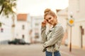 Happy young woman smiling in a fashionable jacket in the city.