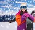 Happy young woman with snowboard over mountains Royalty Free Stock Photo