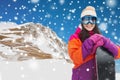 Happy young woman with snowboard over mountains Royalty Free Stock Photo