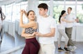 Happy young woman in sportswear with man dancing bachata in ballroom dance class Royalty Free Stock Photo