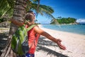 Happy young woman standing with backpack on coast sea and lookin Royalty Free Stock Photo