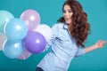 Happy young woman standing over blue wall and holding balloons. Royalty Free Stock Photo