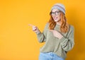 Happy young woman while standing and pointing to blank space - copy space. Girl with happy laugh, half length body, isolated on Royalty Free Stock Photo