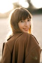 Happy young woman standing on sand on the beach at sunset. Royalty Free Stock Photo