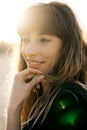 Happy young woman standing on sand on the beach at sunset. Royalty Free Stock Photo