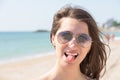 Happy Young Woman Sticking Out Tongue On Beach Royalty Free Stock Photo