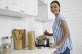 Gladsome woman stirring spaghetti in the kitchen stock photo