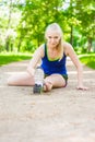 Happy young woman stretching before running outdoors Royalty Free Stock Photo