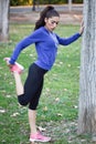 Happy young woman stretching before running outdoors Royalty Free Stock Photo