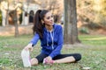 Happy young woman stretching before running outdoors Royalty Free Stock Photo