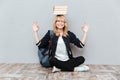 Happy young woman student holding books on head. Royalty Free Stock Photo