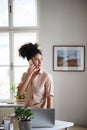 Happy young woman with smartphone working indoors at home, home office concept. Royalty Free Stock Photo