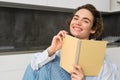 Happy young woman studying at home, reading journal, preparing for exam, looking at her notes in notebook Royalty Free Stock Photo