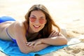 Happy young woman with sunglasses lying on sand and looking at camera. Portrait of beautiful smiling woman lying on tropical beach Royalty Free Stock Photo
