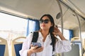 Happy young woman in sunglasses sitting inside public bus transport, enjoying travel transportation trip Royalty Free Stock Photo